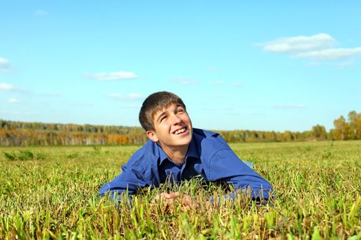 happy teenager lying in the field and looking on the sky