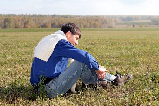 handsome teenager sitting in the field