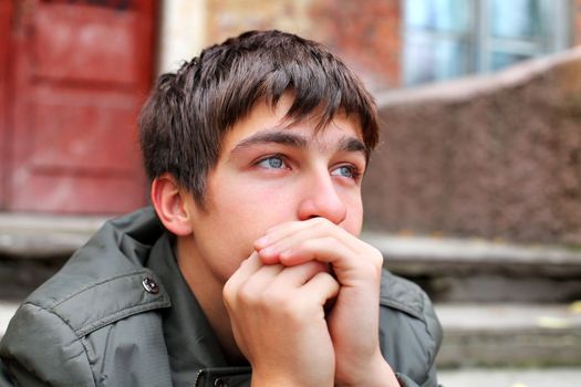 sad young man portrait on the old house background