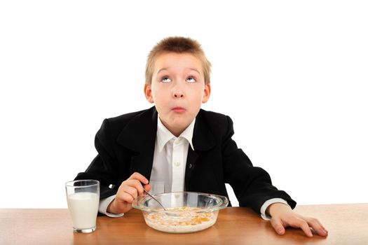 schoolboy eating corn flakes isolated on the white