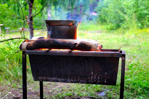 Preparing food on campfire in wild camping