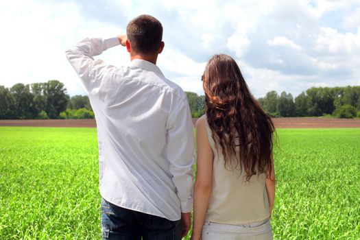 young man and teenage girl in the summer field