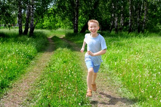 happy boy running in the summer forest