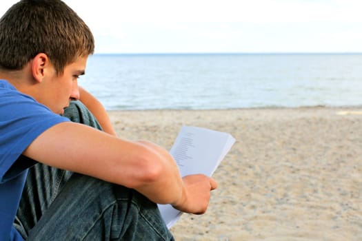 teenager reading letter on the empty beach