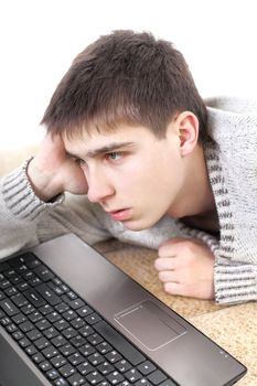 serious teenager with notebook working in home on sofa