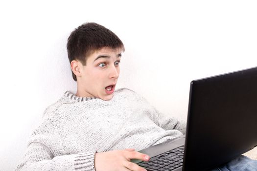 surprised young man with notebook on sofa