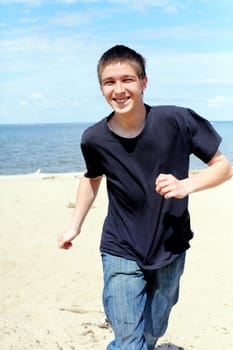 happy teenager running on the beach