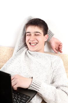 happy young man with notebook on sofa