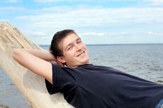 happy young man resting near the water