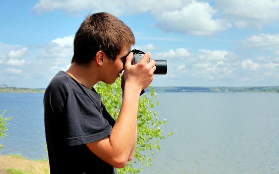 young man with digital photo camera aiming outdoor