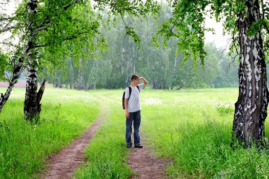 teenager with knapsack get lost in summer forest