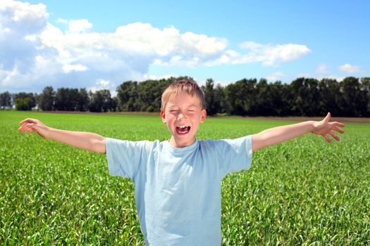 boy spread his hands in the summer field