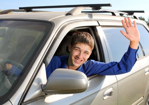 happy young man sit in the car and give salute gesture