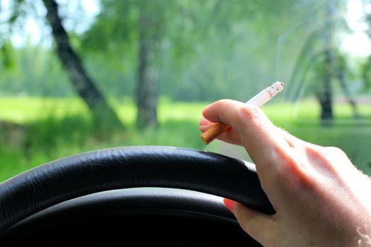 hand of the car driver with cigarette closeup