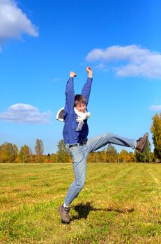 happy teenager jumping in the autumn field