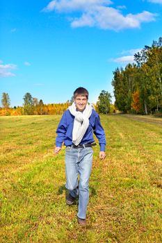 happy teenager running on the autumn field