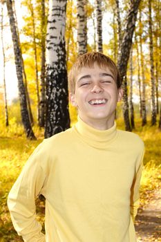 cheerful teenage boy portrait in autumn forest