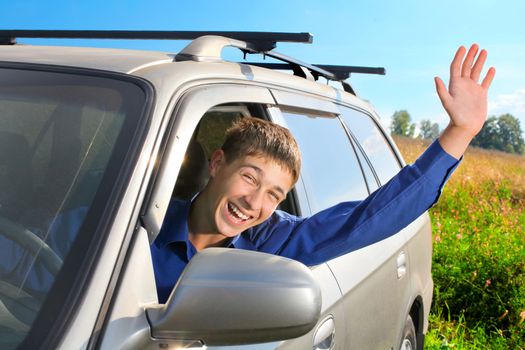 happy young man sit in the car and give salute gesture