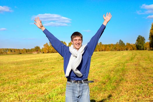 happy teenager with hands up in the autumn field