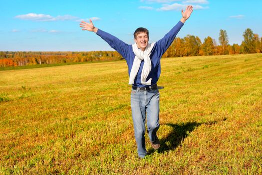 happy teenager with hands up in the autumn field