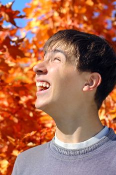 happy teenager on the autumn tree foliage background