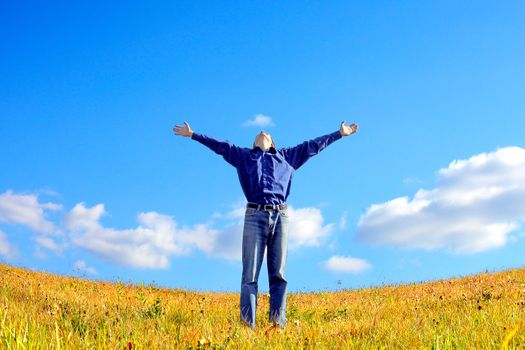 happy young man raising his hands in the autumn field