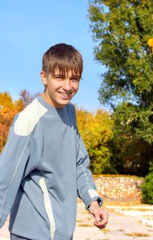 cheerful teenager walking in the autumn park