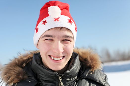 happy young man in santa's hat outdoor in the winter