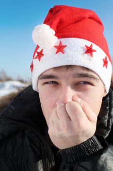 frozen young man in santa's hat in the winter