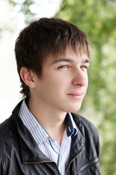 portrait of smiling teenager on the trees background