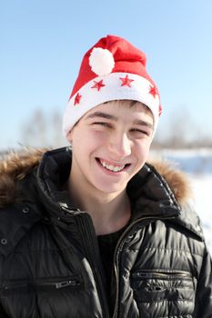 happy young man in santa's hat outdoor in the winter