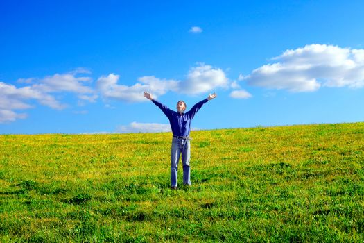 happy young man raising his hands in the summer field