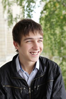 portrait of smiling teenager on the trees background