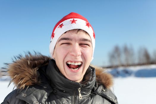 happy young man in santa's hat outdoor in the winter