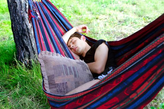 Young Man sleeping in the Hammock on the Nature