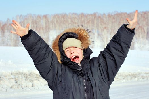 Happy Boy with Hands up in the Winter field