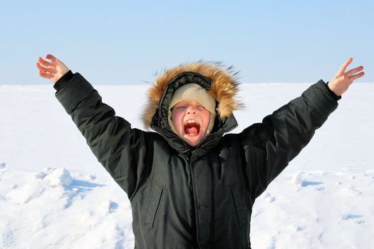 Happy Boy with Hands up in the Winter field