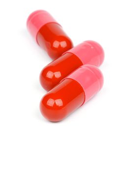 Three Red and Pink Pill Capsules isolated on white background