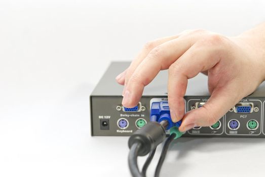 KVM (keyboard, video and mouse) switch and a human hand with an VGA (Video Graphics Array) connector on white background