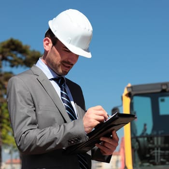 young man with hardhat on building site