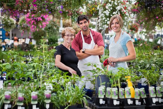 Portrait of florists standing with female customer