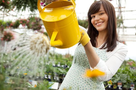 Portrait of an attractive female water plants with a watering can