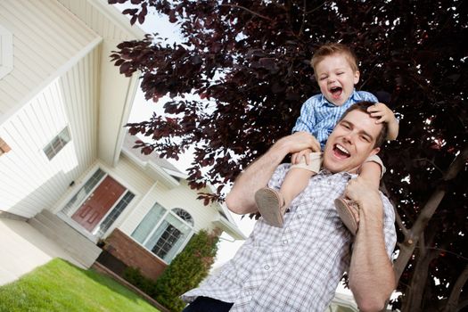 Cheerful handsome father with toddler son on his shoulders