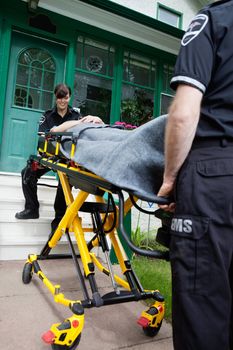 Ambulance worker smiling to patient outside house
