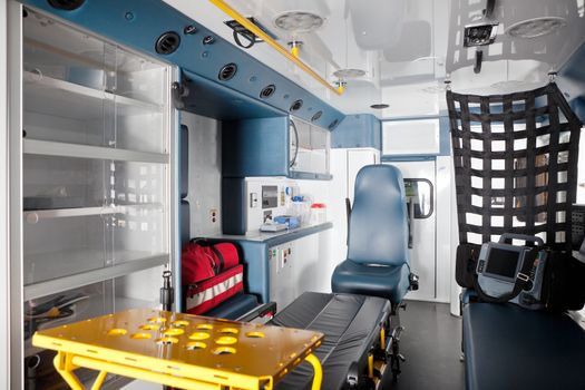 Empty ambulance interior with equipment on bench