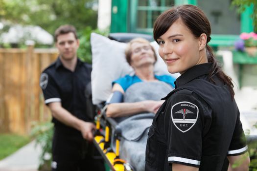 Ambulance worker portrait with stretcher, paitient and co-worker