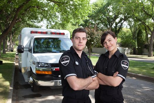Portrait of two paramedics standing in front of ambulance vehicle