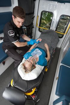 Ambulance professional with senior woman on stretcher