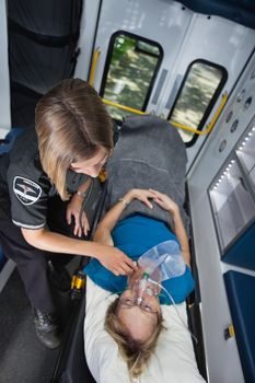 Senior woman in ambulance receiving emergency medical care