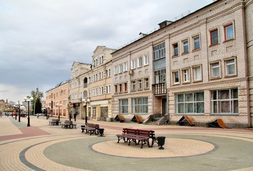 Old houses and benches on a sidewalk